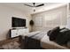 Comfortable bedroom featuring a black ceiling fan, gray decor, a TV, and a large window at 3654 E San Pedro Pl, Chandler, AZ 85249