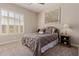 Cozy bedroom offers comfortable bedding, neutral colors, shutters, and a classic bedside table with lamp at 3654 E San Pedro Pl, Chandler, AZ 85249
