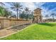 Elegant community entrance with a stone tower, lush landscaping, and manicured lawn, creating a grand arrival at 3654 E San Pedro Pl, Chandler, AZ 85249