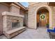 Inviting front entrance with a fireplace, stone accents, and a wooden front door with a wreath at 3654 E San Pedro Pl, Chandler, AZ 85249