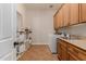 Well-organized laundry room includes a sink, storage cabinets, a folding area, and a modern washer/dryer set at 3654 E San Pedro Pl, Chandler, AZ 85249