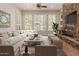 Comfortable living room featuring a stone fireplace, large windows, neutral furnishings, and ample seating at 3654 E San Pedro Pl, Chandler, AZ 85249