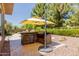 Outdoor kitchen with built-in grill and bar seating, under a yellow umbrella at 3654 E San Pedro Pl, Chandler, AZ 85249