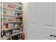 Organized pantry with multiple shelves stocked with food items next to a white door at 3654 E San Pedro Pl, Chandler, AZ 85249