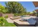 Outdoor pool area featuring a spa, fire pit, lush greenery, and covered patio seating at 3654 E San Pedro Pl, Chandler, AZ 85249