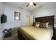 Bedroom with a large bed, tv, luggage rack and ceiling fan at 41199 W Granada Dr, Maricopa, AZ 85138