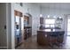 Bright kitchen with stainless steel appliances, an island with seating, and warm wood cabinets at 41250 W Thornberry Ln, Maricopa, AZ 85138