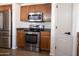 Stainless steel appliances including a refrigerator, oven, and microwave in kitchen with wood cabinets at 41250 W Thornberry Ln, Maricopa, AZ 85138