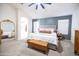 Bright main bedroom featuring an accent wall, comfortable bed, and ample natural light at 41250 W Thornberry Ln, Maricopa, AZ 85138