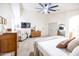 Cozy primary bedroom with coordinated furniture, ceiling fan, and ample natural light at 41250 W Thornberry Ln, Maricopa, AZ 85138