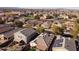 High angle view of a suburban neighborhood featuring diverse homes with tile roofs, lush trees, and well-kept streets at 41250 W Thornberry Ln, Maricopa, AZ 85138