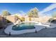 Lush backyard showcasing a sparkling pool with a rock waterfall and serene landscaping at 41250 W Thornberry Ln, Maricopa, AZ 85138