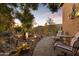 The landscaped backyard features a charming rock garden, a tranquil water feature, and a cozy seating area at 42988 W Misty Morning Ln, Maricopa, AZ 85138