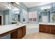 Bright bathroom features double vanity, large mirror, tile floors, and a soaking tub under a shuttered window at 42988 W Misty Morning Ln, Maricopa, AZ 85138