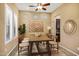 Bright dining room with natural light, shutters, neutral decor, rustic table, and seating for six at 42988 W Misty Morning Ln, Maricopa, AZ 85138
