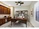 Stylish home office with built-in shelving, large desk, and neutral color palette for a professional workspace at 42988 W Misty Morning Ln, Maricopa, AZ 85138