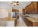 This eat-in kitchen features granite countertops, stainless appliances, dark wood cabinets, and a center island with bar seating at 42988 W Misty Morning Ln, Maricopa, AZ 85138