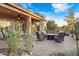 Inviting outdoor patio features a cozy fire pit, comfortable seating, lush landscaping, and a covered area at 42988 W Misty Morning Ln, Maricopa, AZ 85138