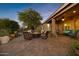 Inviting outdoor patio features a cozy fire pit, comfortable seating, lush landscaping, and a covered area at 42988 W Misty Morning Ln, Maricopa, AZ 85138