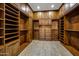 Spacious walk-in closet boasts custom shelving and cabinetry for optimal organization and storage at 42988 W Misty Morning Ln, Maricopa, AZ 85138
