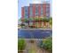 Modern apartment building with red accents and rows of palm trees along the street at 4808 N 24Th St # 1402, Phoenix, AZ 85016