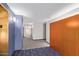 Hallway with carpet flooring and blue-purple walls with wood panels and bright overhead lighting at 4808 N 24Th St # 1402, Phoenix, AZ 85016