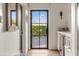Welcoming entryway with a black framed door and a view of the lush greenery outside at 5101 N Casa Blanca Dr # 25, Paradise Valley, AZ 85253