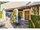 Inviting front entrance features natural stone walkway, wood door and beams, with desert landscaping and cozy outdoor seating area at 5101 N Casa Blanca Dr # 25, Paradise Valley, AZ 85253