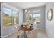 Bright dining area with large windows, a modern chandelier, and seating for four, bathed in natural light at 538 E Pasaro Dr, Phoenix, AZ 85085