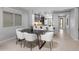 Dining area with a dark table and modern white chairs, located adjacent to a well-equipped kitchen at 538 E Pasaro Dr, Phoenix, AZ 85085