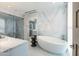 Contemporary bathroom with marble walls, a freestanding tub, and a glass-enclosed shower at 6587 N Palmeraie Blvd # 2041, Paradise Valley, AZ 85253