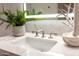 Bright bathroom sink with a Waterworks faucet, marble countertop, decorative plant and mirror at 6587 N Palmeraie Blvd # 2041, Paradise Valley, AZ 85253