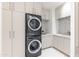 Efficient laundry room featuring stacked washer and dryer, custom cabinets, and modern design elements at 6587 N Palmeraie Blvd # 2041, Paradise Valley, AZ 85253
