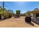 Backyard featuring a covered patio, hardscape walkway, a small tree, a privacy wall, and a swing set at 7327 N 21St Ave, Phoenix, AZ 85021