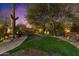Expansive backyard featuring mature trees, lush lawn, and outdoor seating area at 7451 E Long Rifle Rd, Carefree, AZ 85377