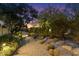 Backyard with desert landscaping, lighting along a walkway, and a variety of cacti at 7451 E Long Rifle Rd, Carefree, AZ 85377