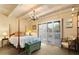 Bedroom with a four poster bed and decorative pillows, chest, and access to the patio at 7451 E Long Rifle Rd, Carefree, AZ 85377