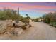 Desert home boasts natural desert landscaping and a gravel driveway at 7451 E Long Rifle Rd, Carefree, AZ 85377
