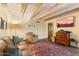 Living room with beamed ceilings, patterned rug, comfortable seating, and access to patio at 7451 E Long Rifle Rd, Carefree, AZ 85377