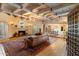 Open living area featuring exposed beam ceilings, a stone fireplace, and views into dining room and kitchen at 7451 E Long Rifle Rd, Carefree, AZ 85377