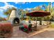 Outdoor patio features a fireplace, umbrella, and seating area at 7451 E Long Rifle Rd, Carefree, AZ 85377