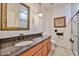 Bathroom featuring a vanity with granite countertops, a decorative mirror, and a glass-enclosed shower at 7667 E Krall St, Scottsdale, AZ 85250