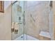 Shower featuring a glass enclosure, stone tiling, bench seating, and a hand-held sprayer at 7667 E Krall St, Scottsdale, AZ 85250