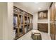 Spacious walk-in closet with custom wood cabinetry and glass doors, providing ample storage at 77 E Missouri Ave # 7, Phoenix, AZ 85012