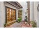 Inviting entryway with wooden double doors, a 'Welcome' mat, and elegant landscaping at 77 E Missouri Ave # 7, Phoenix, AZ 85012