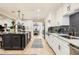 Open-concept kitchen featuring an island, modern appliances, white cabinets, and hardwood flooring at 77 E Missouri Ave # 7, Phoenix, AZ 85012