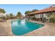 Community pool with tiled patio, lounge chairs, tables with chairs, and a covered patio at 77 E Missouri Ave # 7, Phoenix, AZ 85012