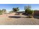 Gravel backyard featuring a small tree, privacy wall, and view of neighborhood at 8354 E Emelita Ave, Mesa, AZ 85208