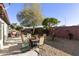 Large backyard with gravel, patio furniture, mature trees, and red brick fence at 8354 E Emelita Ave, Mesa, AZ 85208