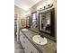 Bathroom featuring dual sinks, a decorative framed mirror and a step-in shower at 8354 E Emelita Ave, Mesa, AZ 85208